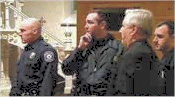The pastor Fr. Thomas DeYoung does a slow boil while lurking behind law enforcement officers he called in.